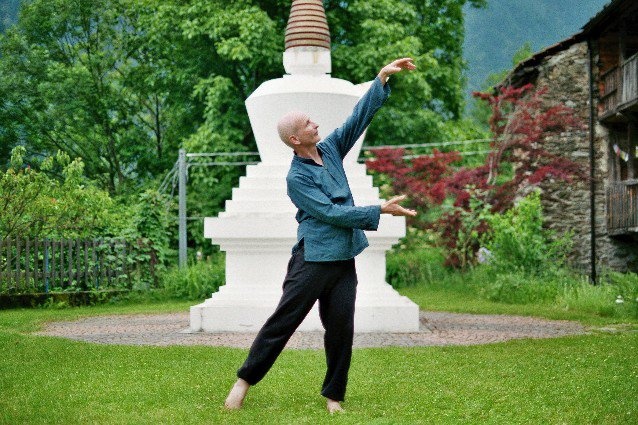 Michael Schuierer bei der Sheng Zhen Meditation im Freien vor einer weißen Stupa